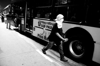 Foto de protestante ao lado de ônibus em São Paulo